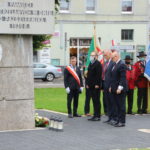 Delegacja władz gminy Mosina stojąca przed "Pomnikiem pamięci"