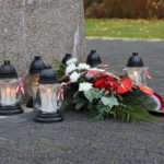 Znicze i wiązanki kwiatów przed Pomnikiem Pamięci